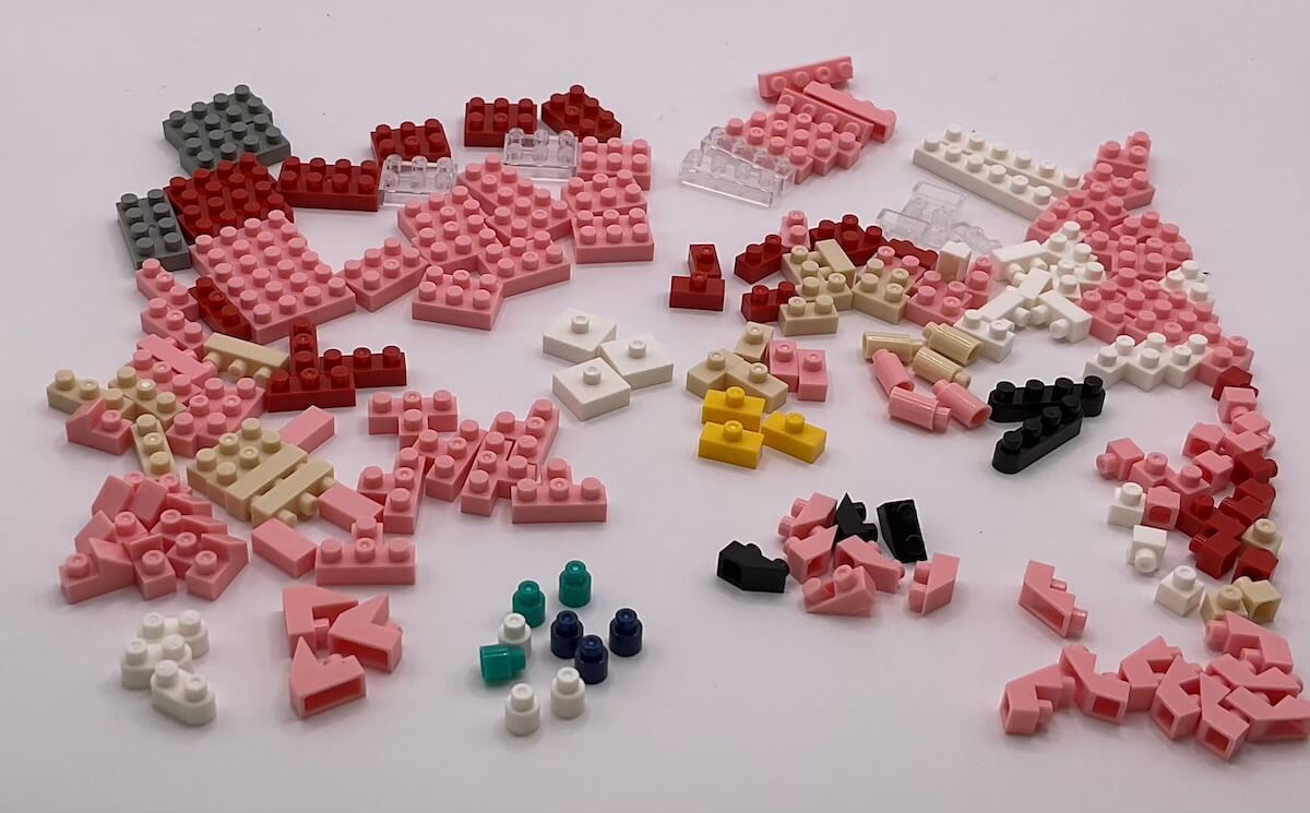 All the pieces for the Nanoblock Amy Rose set, loosely sorted by type and color on a white background.